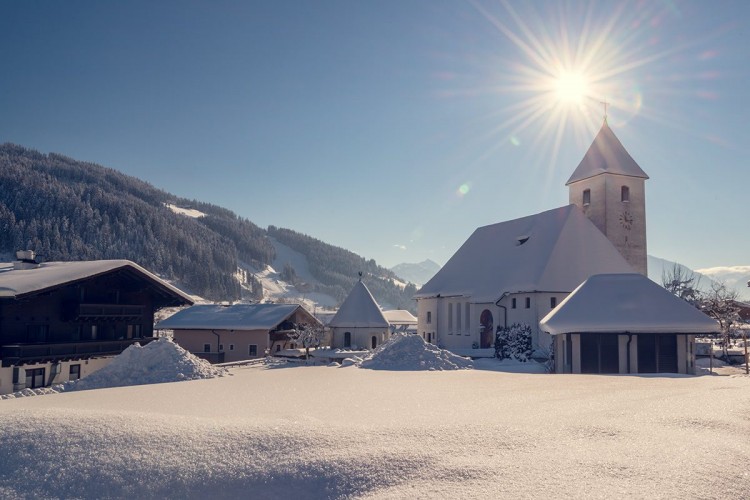 Dorf mit Kirche und Blick auf die monte popolo Skipiste